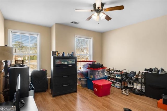 office featuring light hardwood / wood-style floors, ceiling fan, and a healthy amount of sunlight