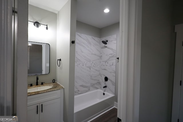 bathroom featuring tiled shower / bath combo and vanity