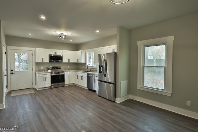 kitchen with sink, dark hardwood / wood-style floors, white cabinets, and appliances with stainless steel finishes