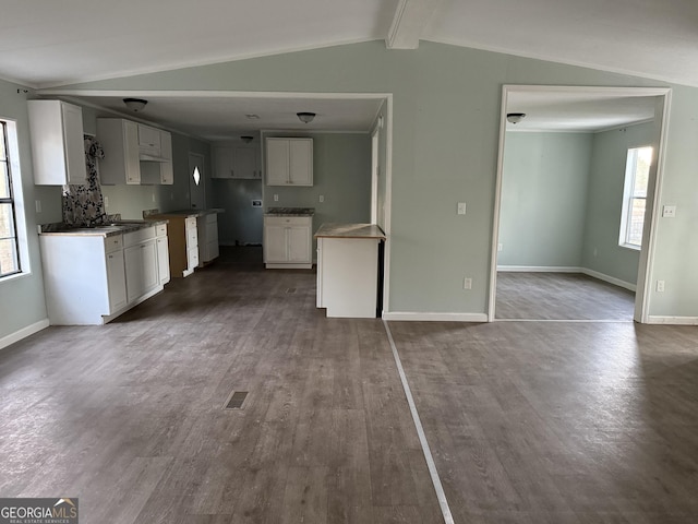 kitchen with hardwood / wood-style floors, a healthy amount of sunlight, white cabinets, and lofted ceiling with beams