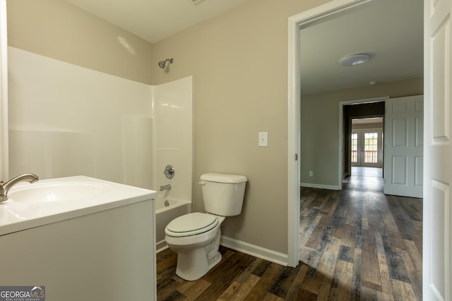 full bathroom with bathing tub / shower combination, toilet, vanity, wood finished floors, and baseboards