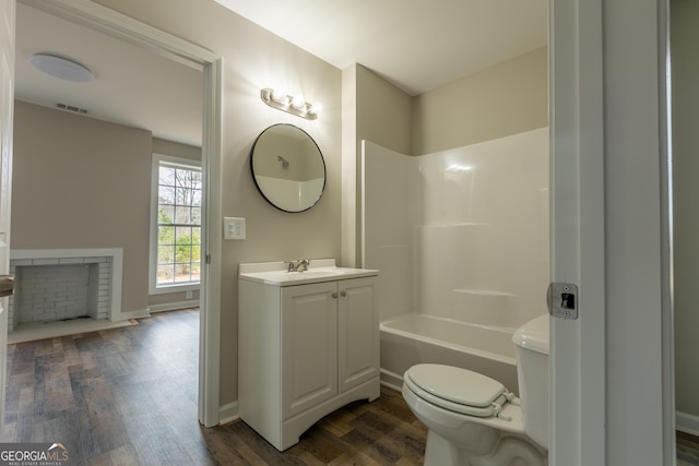 bathroom featuring visible vents, toilet, vanity, wood finished floors, and baseboards