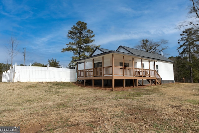 rear view of property with a yard, fence, and a wooden deck