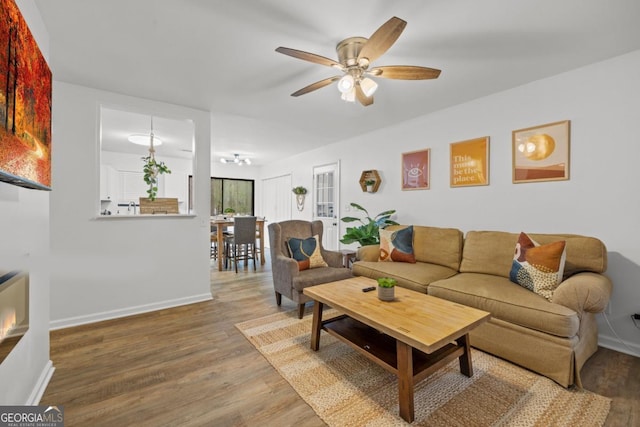 living room with ceiling fan and hardwood / wood-style floors