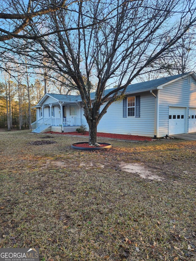 single story home featuring covered porch and a garage