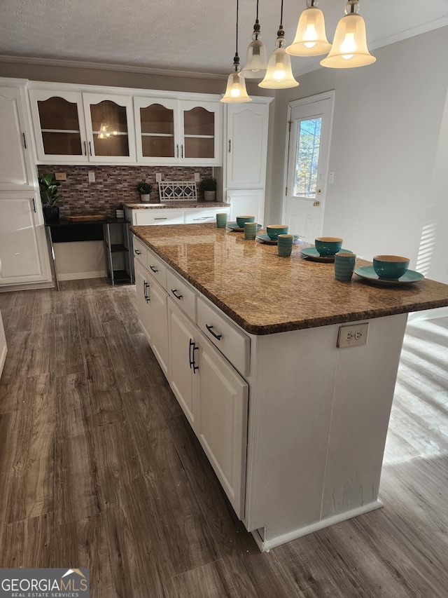 kitchen with backsplash, decorative light fixtures, dark hardwood / wood-style flooring, a kitchen island, and white cabinets