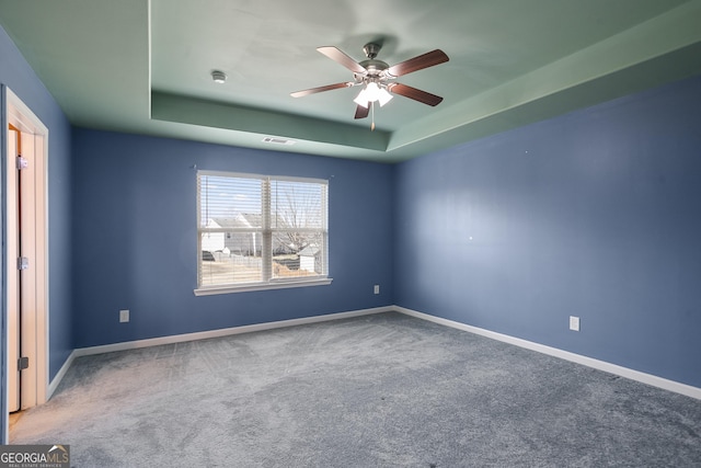 unfurnished room with carpet floors, ceiling fan, and a tray ceiling