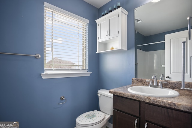 bathroom featuring toilet, walk in shower, and vanity