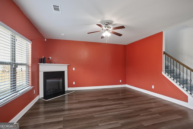 unfurnished living room featuring ceiling fan and dark hardwood / wood-style flooring