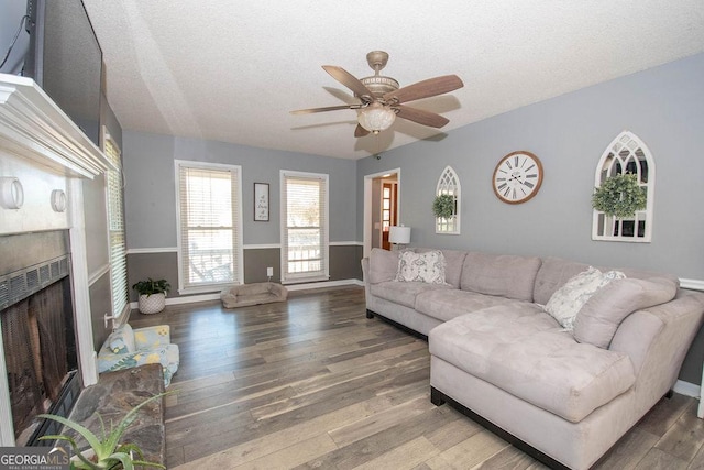 living room featuring ceiling fan, a textured ceiling, and hardwood / wood-style floors