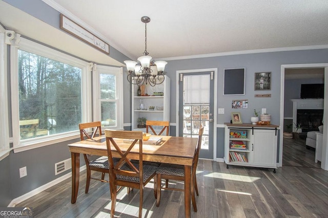 dining room featuring an inviting chandelier, dark hardwood / wood-style flooring, and ornamental molding