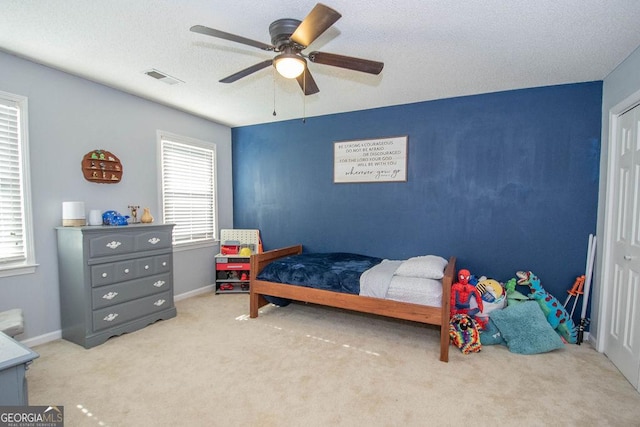 carpeted bedroom with a textured ceiling and ceiling fan