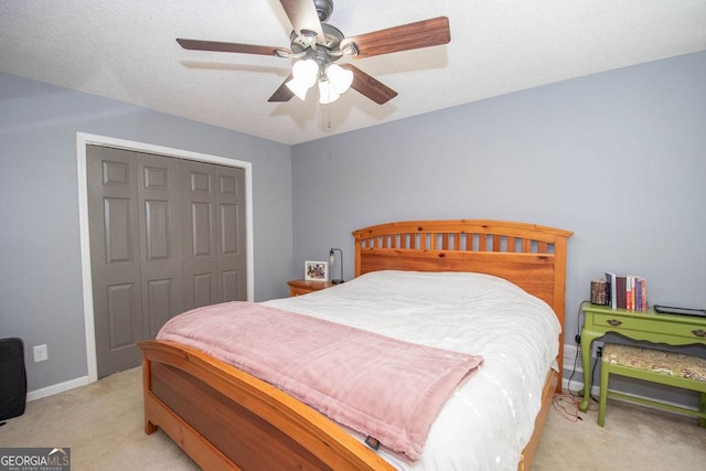 carpeted bedroom featuring ceiling fan and a closet