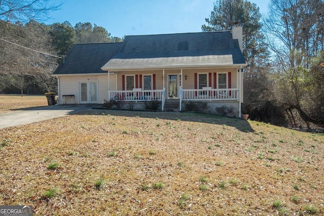 single story home with a front yard, covered porch, and french doors