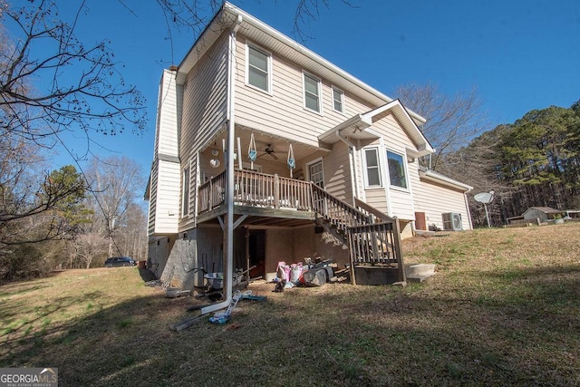 rear view of house featuring ceiling fan, cooling unit, and a yard