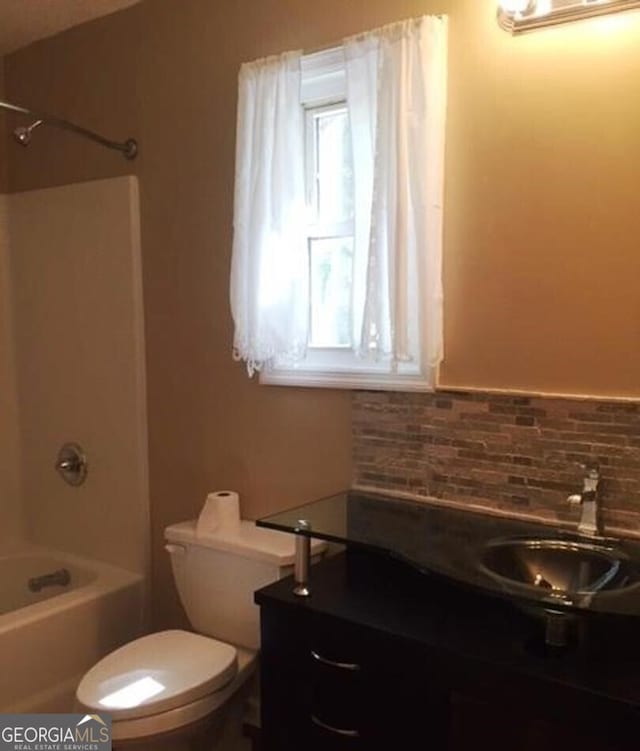 full bathroom featuring decorative backsplash, toilet, vanity, and bathing tub / shower combination