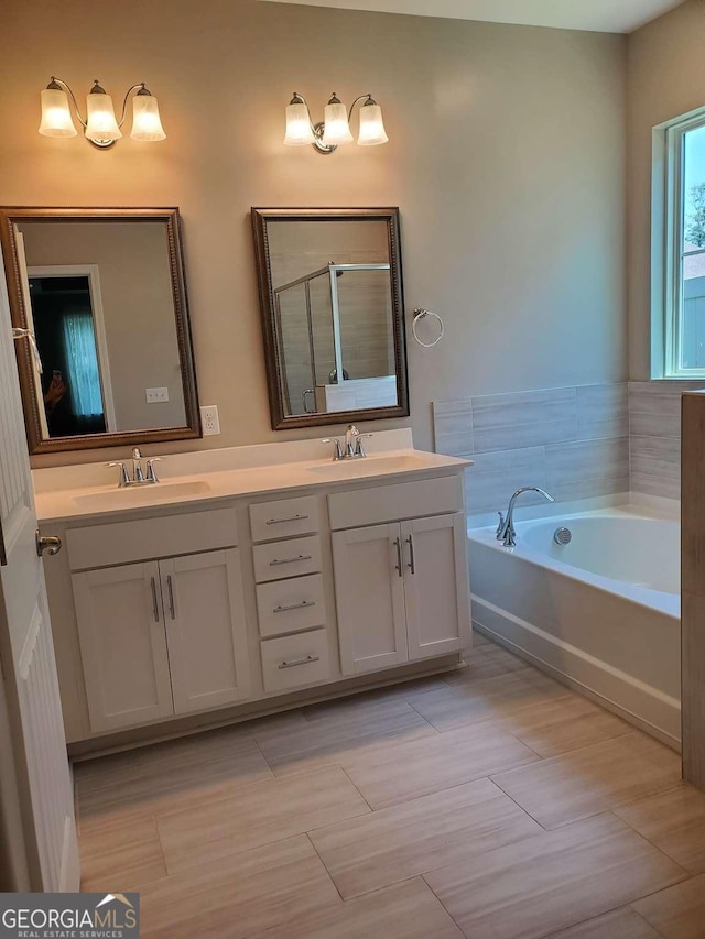 bathroom featuring separate shower and tub and vanity