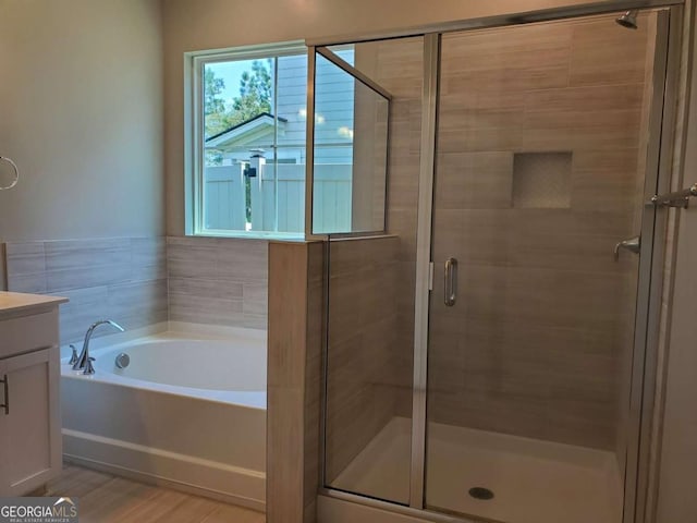 bathroom featuring vanity, independent shower and bath, and hardwood / wood-style floors