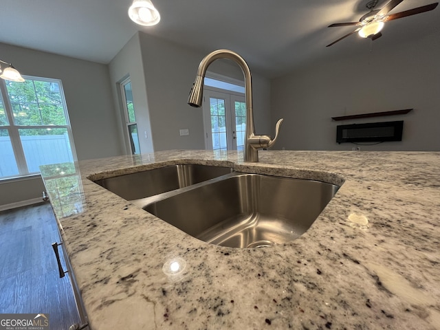 143 Madeira Dr, Brunswick, GA 31523 - kitchen featuring a sink, french doors, light stone countertops, and plenty of natural light