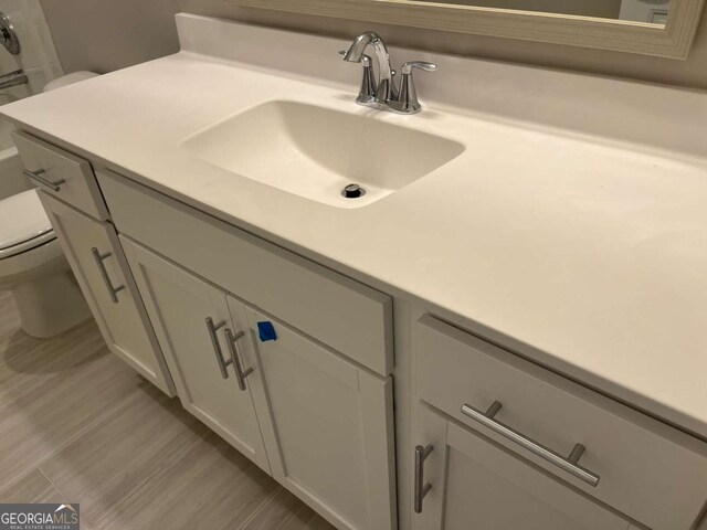 bathroom featuring hardwood / wood-style flooring, toilet, and vanity