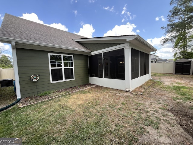 143 Madeira Dr, Brunswick, GA 31523 - rear view of house with a sunroom, roof with shingles, and central AC