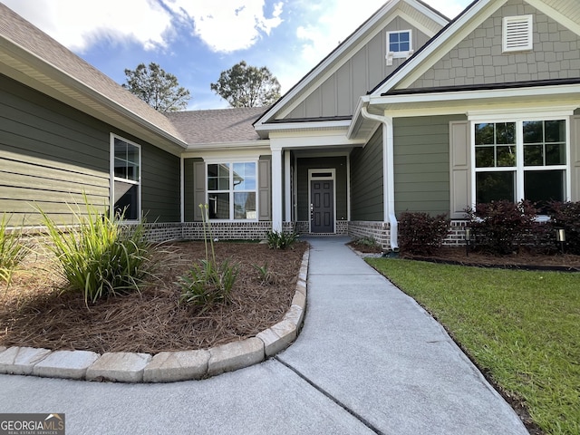 143 Madeira Dr, Brunswick, GA 31523 - property entrance featuring board and batten siding, a lawn, and a shingled roof