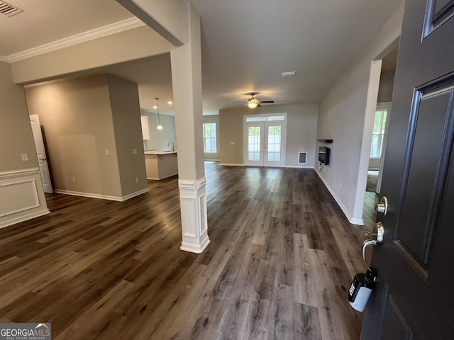 143 Madeira Dr, Brunswick, GA 31523 - unfurnished living room featuring dark wood finished floors, ceiling fan, a glass covered fireplace, crown molding, and baseboards