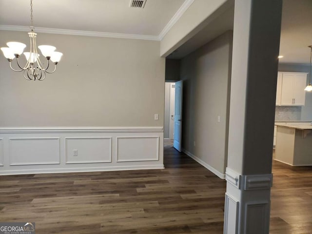 unfurnished dining area featuring dark hardwood / wood-style flooring, crown molding, and a notable chandelier