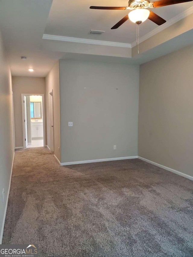 carpeted spare room featuring crown molding, ceiling fan, and a tray ceiling