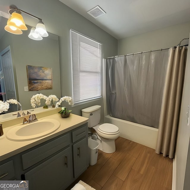 full bathroom with shower / tub combo with curtain, vanity, hardwood / wood-style flooring, and toilet