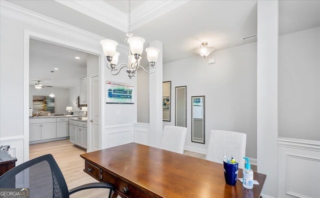 dining area featuring crown molding, ceiling fan with notable chandelier, and light hardwood / wood-style floors