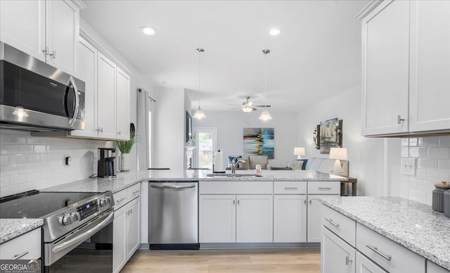 kitchen featuring backsplash, appliances with stainless steel finishes, sink, and white cabinetry