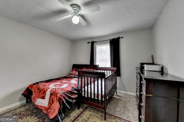 carpeted bedroom featuring a textured ceiling and ceiling fan