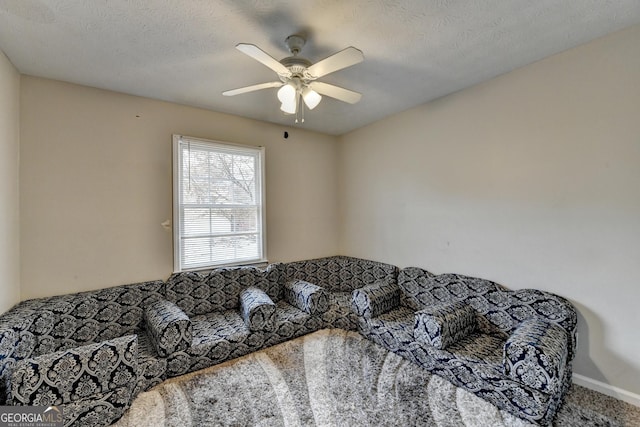 living room with ceiling fan, carpet, and a textured ceiling