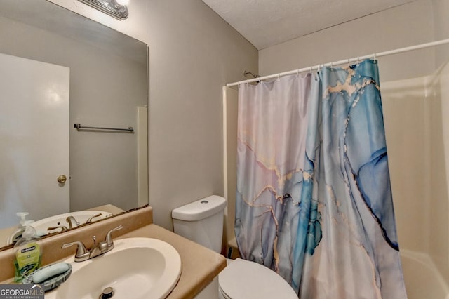 full bathroom featuring shower / tub combo with curtain, vanity, toilet, and a textured ceiling