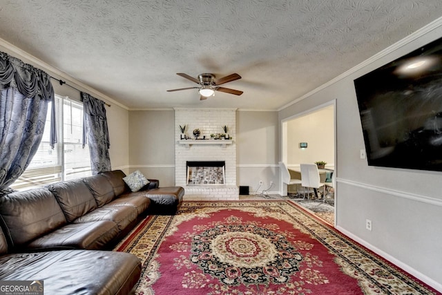 living room with ceiling fan, a fireplace, ornamental molding, and a textured ceiling