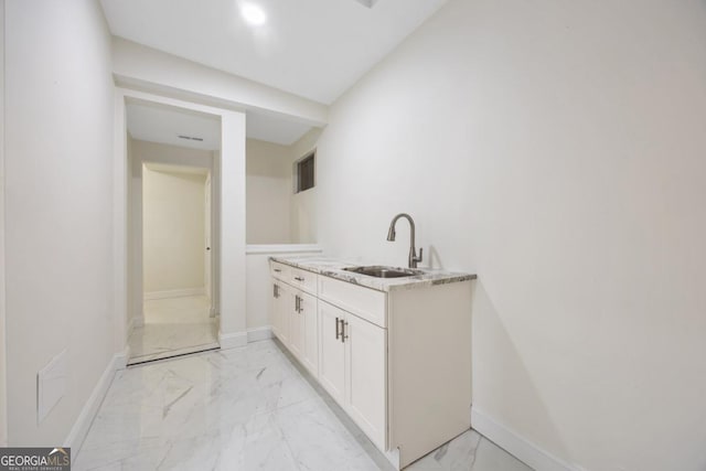 interior space with white cabinets and sink