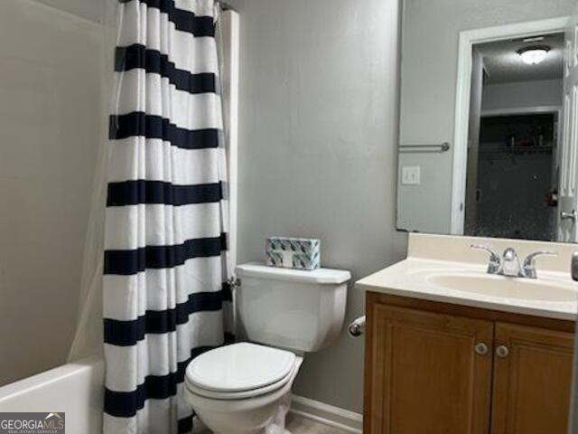 full bathroom with vanity, shower / bath combination with curtain, and toilet