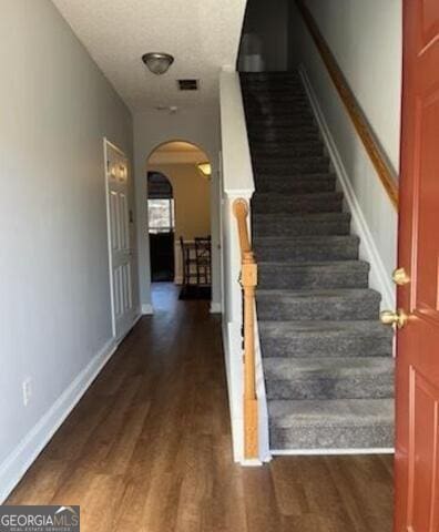 staircase featuring hardwood / wood-style flooring and a textured ceiling