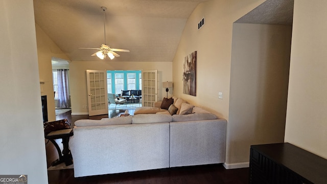 living room featuring ceiling fan, vaulted ceiling, dark wood-type flooring, and french doors