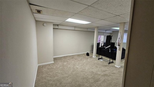 finished basement featuring a drop ceiling, carpet, visible vents, and baseboards