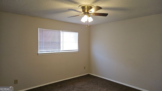 unfurnished room featuring a ceiling fan, dark carpet, a textured ceiling, and baseboards