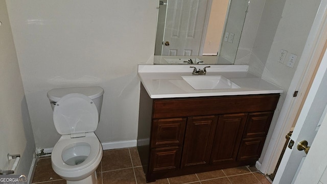 half bathroom with baseboards, vanity, toilet, and tile patterned floors