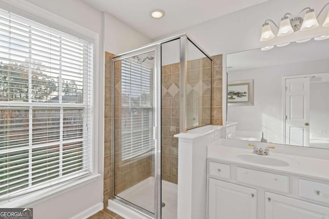 bathroom with a shower with shower door, vanity, and tile patterned flooring