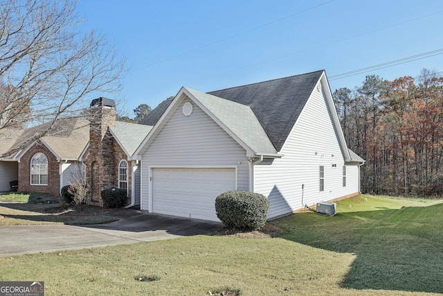 view of front of home with a garage, a front lawn, and central air condition unit