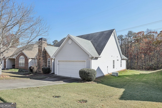 view of front of house with a garage, a front lawn, and central AC unit