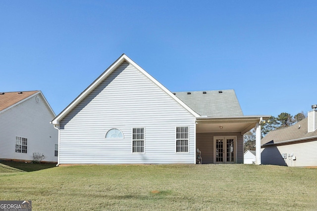 back of property featuring a yard