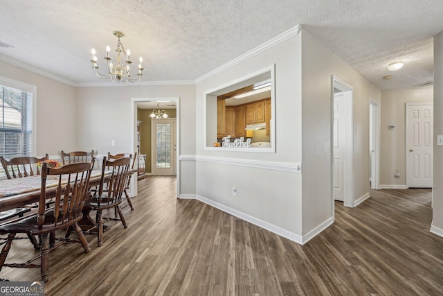 dining space with a textured ceiling, ornamental molding, dark hardwood / wood-style floors, and a notable chandelier