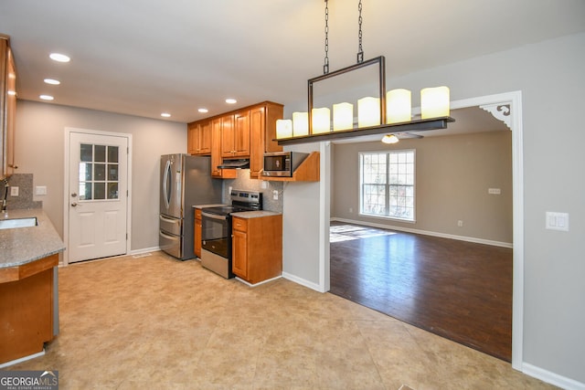 kitchen with stainless steel appliances, decorative backsplash, sink, hanging light fixtures, and light tile patterned floors