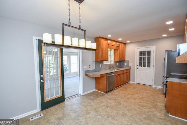 kitchen featuring hanging light fixtures, decorative backsplash, dishwasher, and sink